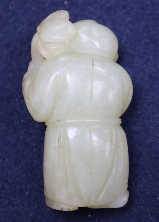 A Chinese pale greenish-yellow jade figure of a boy holding a sprig of lotus, 18th/19th century, 5.9cm